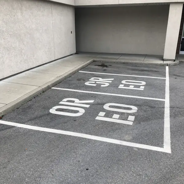 Stencilled compact stall legend on asphalt Stencilled compact stall legend on asphalt